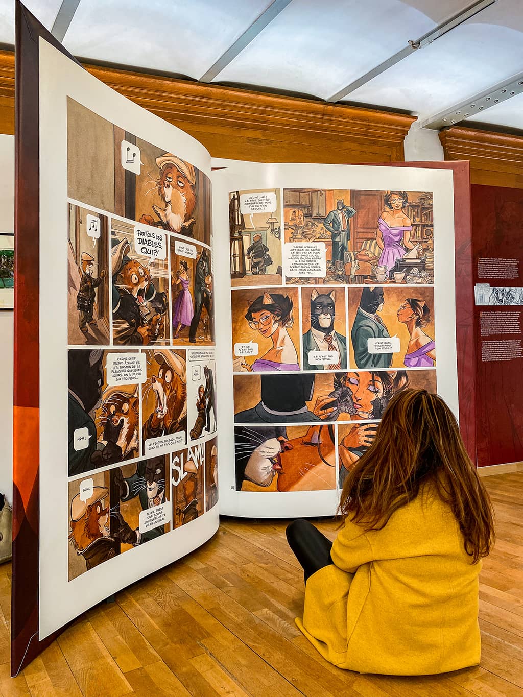 Une jeune femme regarde une grande BD au musée de la BD de Bruxelles