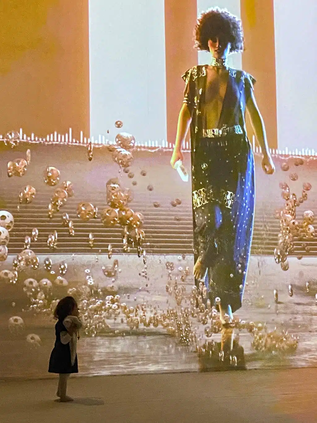 Une petite fille devant le grand écran projetant les oeuvres de Klimt lors de l'expostion immersive de Bruxelles