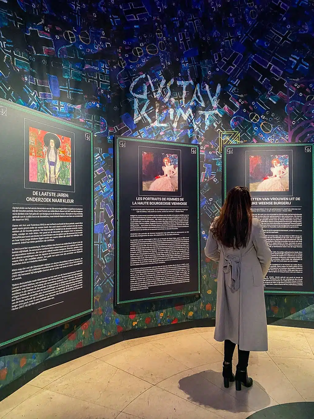 Une jeune femme lit les panneaux explicatifs à l'exposition Klimt de Bruxelles