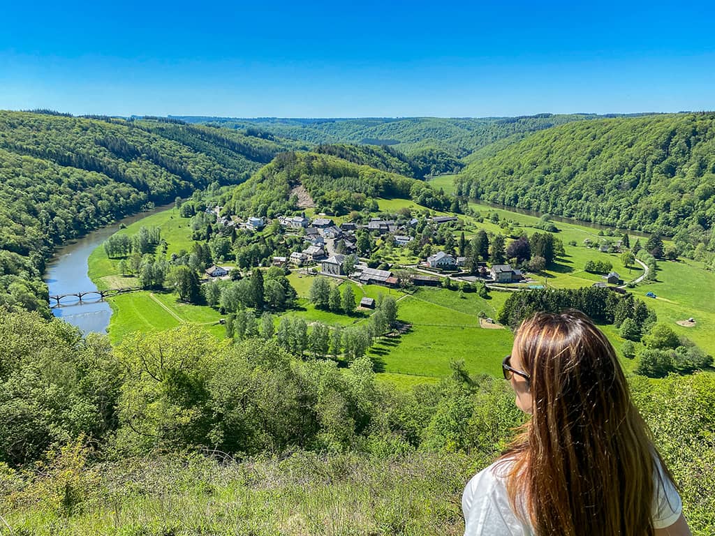Une jeune femme profite de la vue sur le village de Frahan depuis le point de vue de Rochehaut.