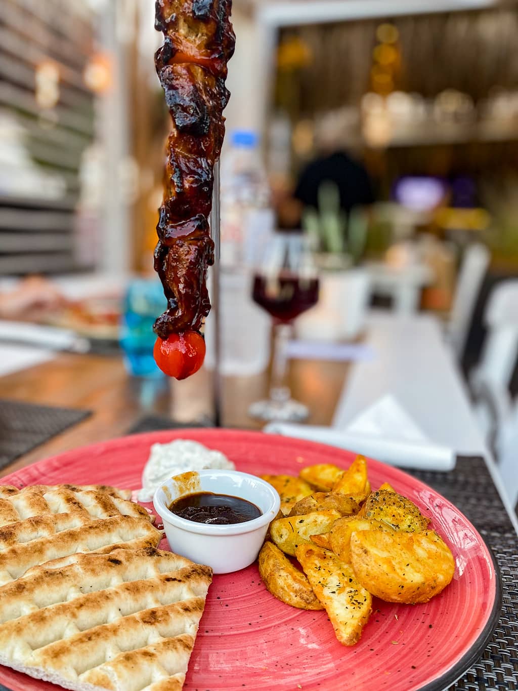 voyage-santorin-40 Brochette de porc suspendue avec des pommes de terre et pain grec au restaurant Alismari de Kamari sur l'île de Santorin