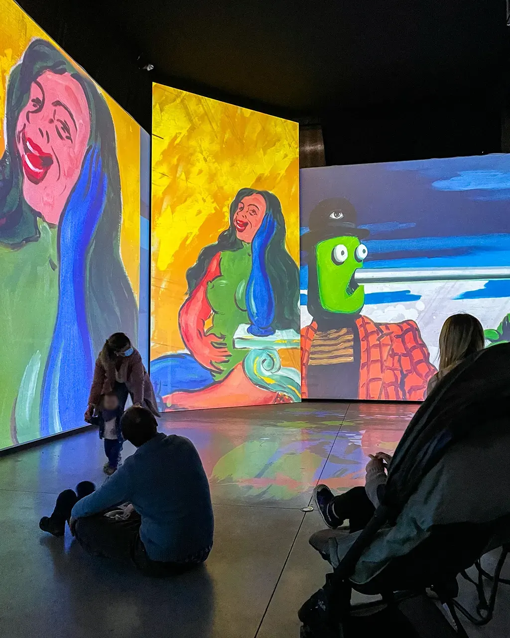 Une petite fille devant le grand écran projetant les oeuvres de Klimt lors de l'expostion immersive de Bruxelles