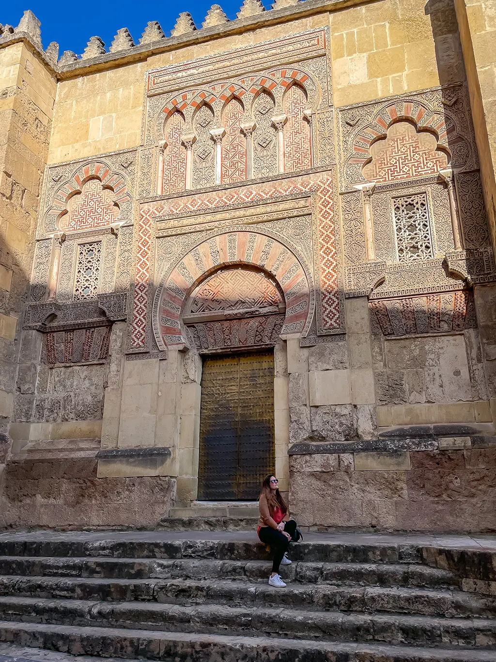 jeune femme assise devant la Grande Mosquée de Cordoue