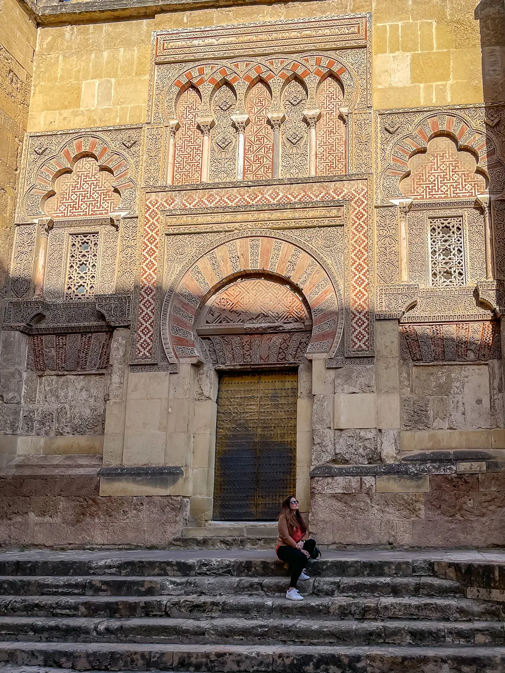 jeune femme assise devant la Mezquita de Cordoue