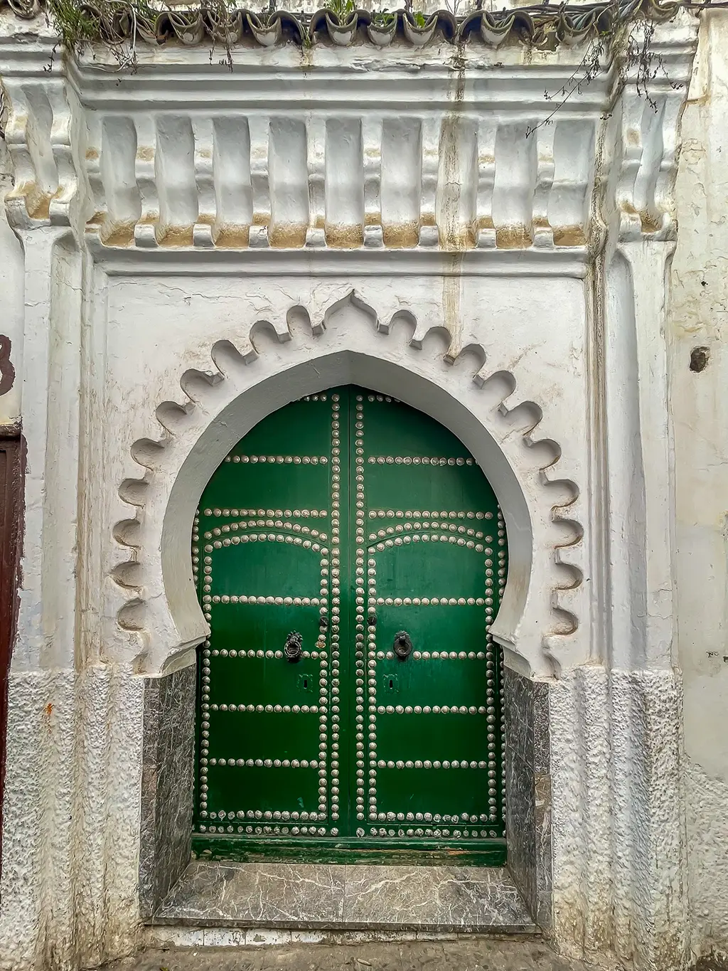 porte verte richement décorée à Tétouan