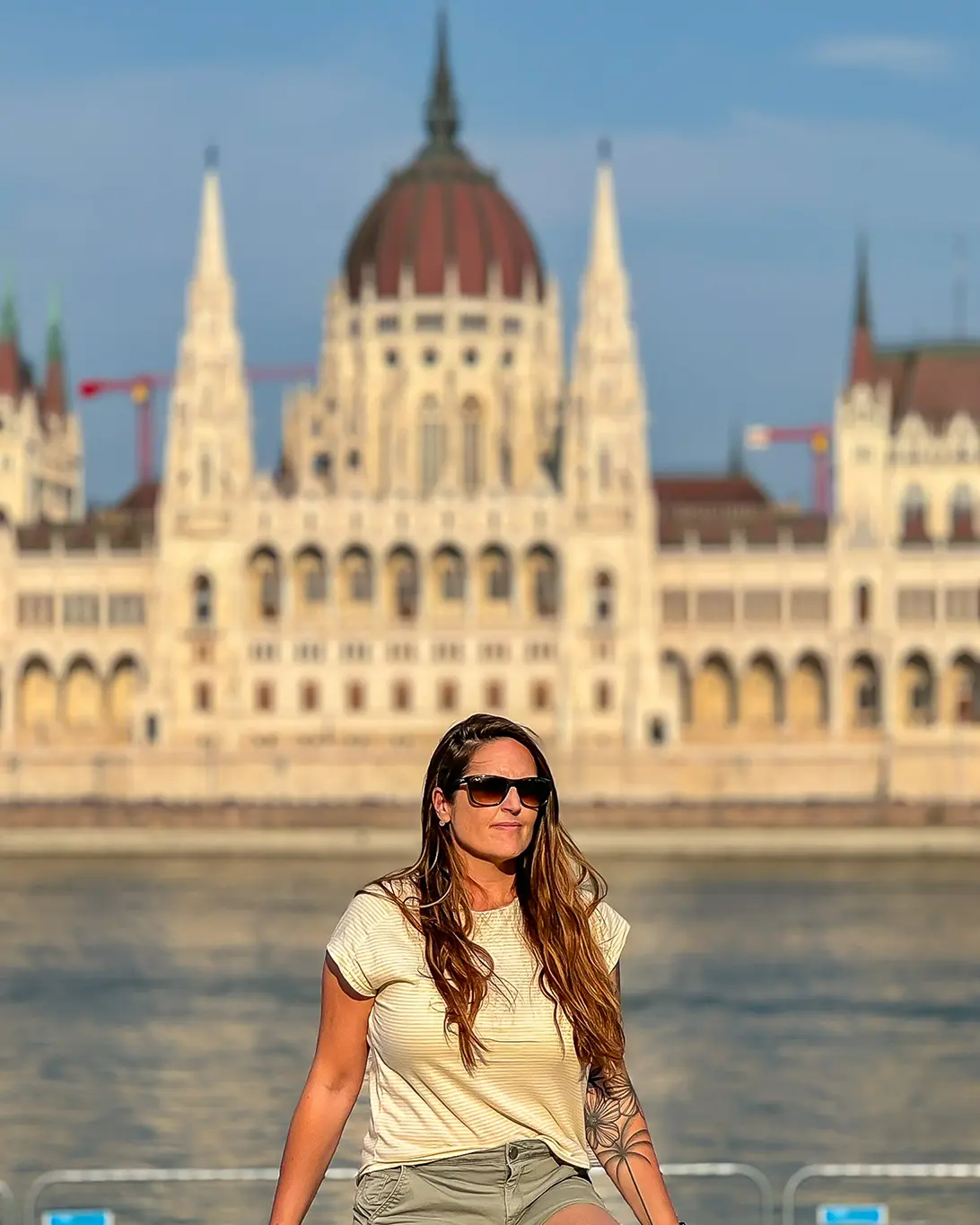 jeune femme qui prend la pose face au parlement hongrois de Budapest