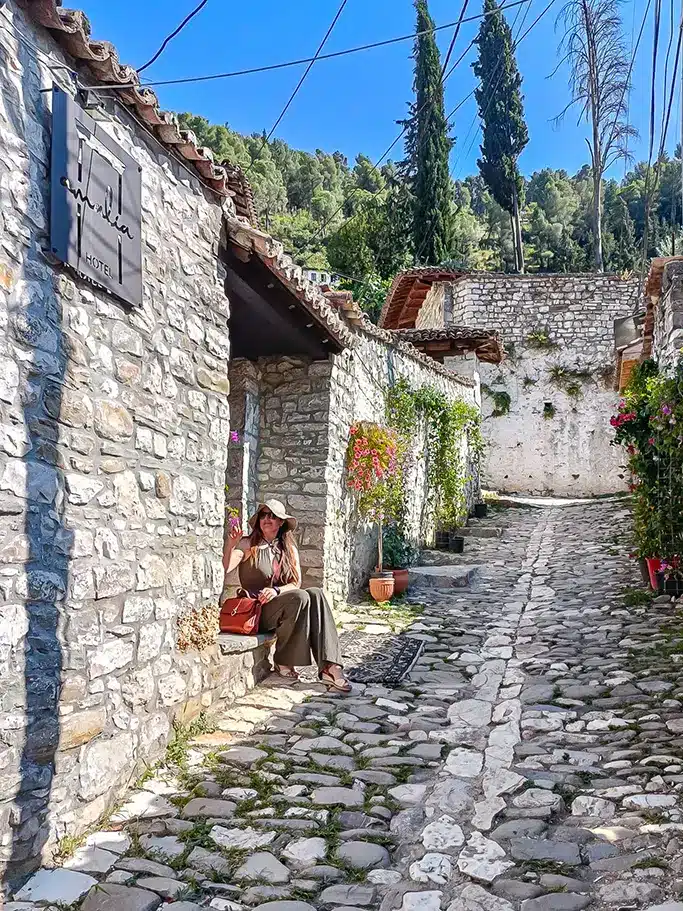 Femme posant dans une ruelle en pierre à Berat (Albanie)