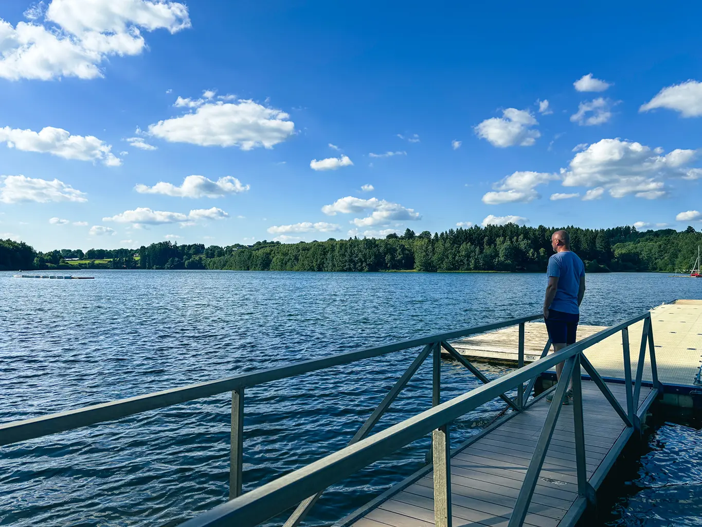 Moment de détente au bord du lac de Nisramont sous un ciel bleu, idéal lors d’un week-end romantique en Ardennes.