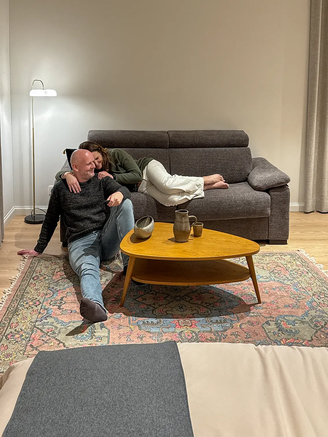 Un couple profite d’un moment paisible sur le balcon en bois du Woodpecker Lodge, en pleine nature, lors d’un week-end romantique en Ardennes.
