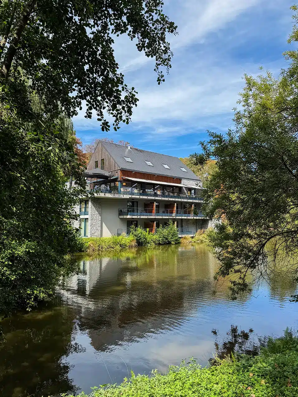 Étang bordé de saules pleureurs devant l’ABCD Restaurant Hôtel à Beauraing