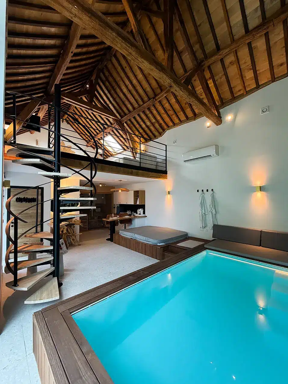 Chambre en mezzanine aménagée sous les poutres de l’ancienne ferme
