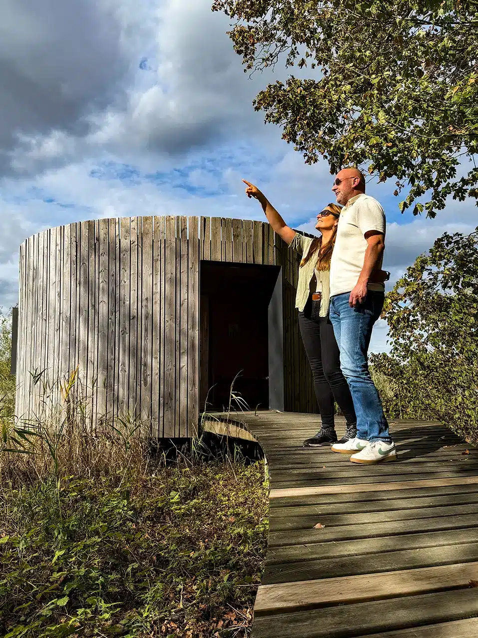 Couple observant la nature devant une cabane en bois de l’Aquascope de Virelles
