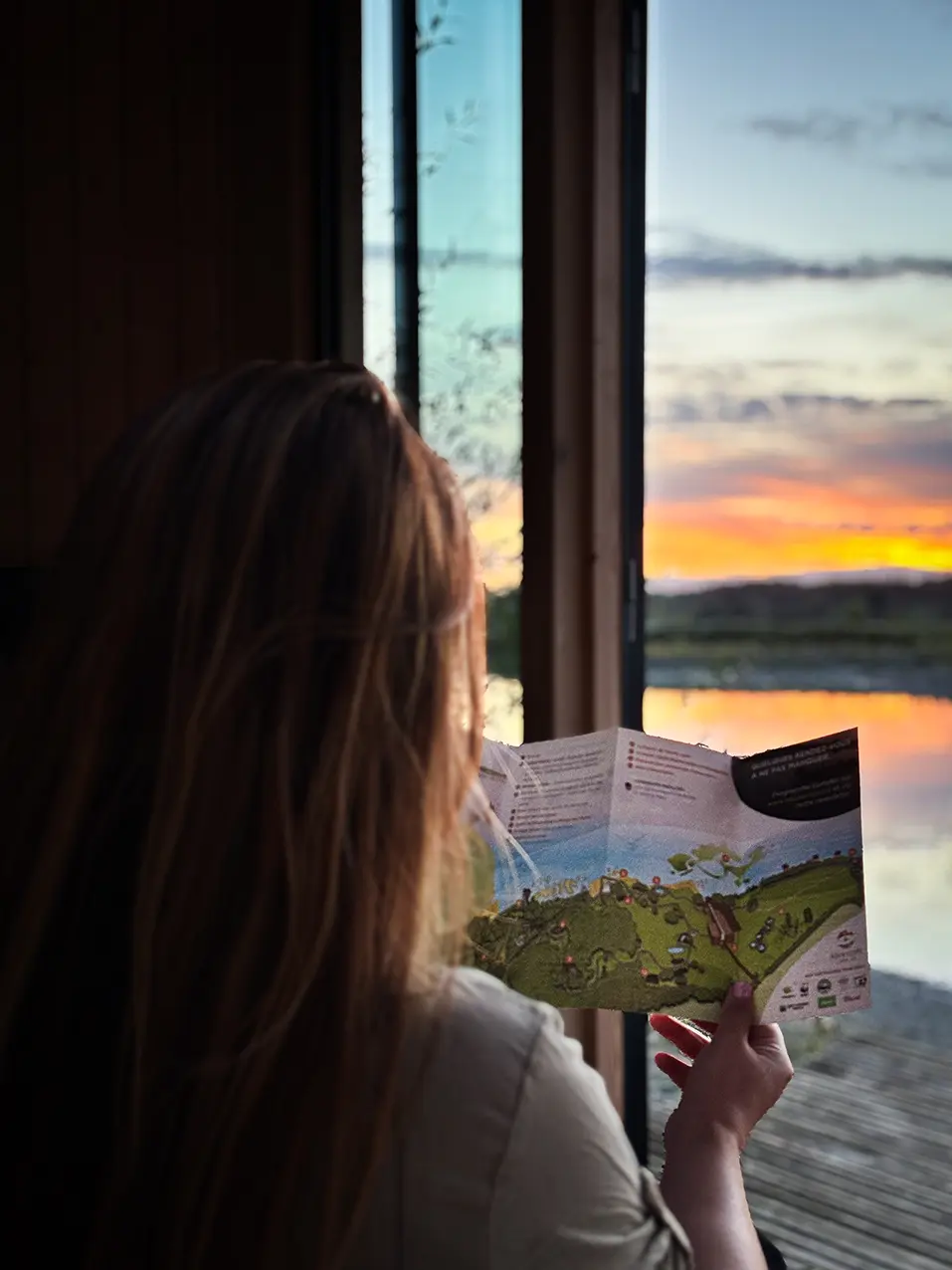 Consultation du guide de l’Aquascope devant le coucher du soleil